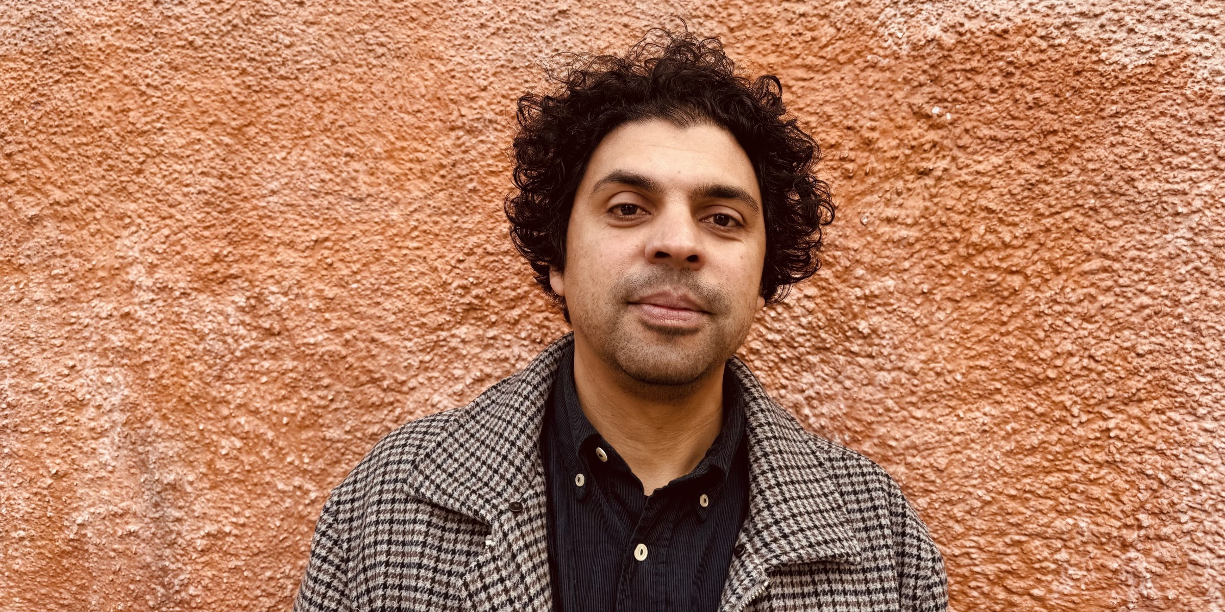 Portrettfoto av Ruhi Tyson foran ein oransje vegg