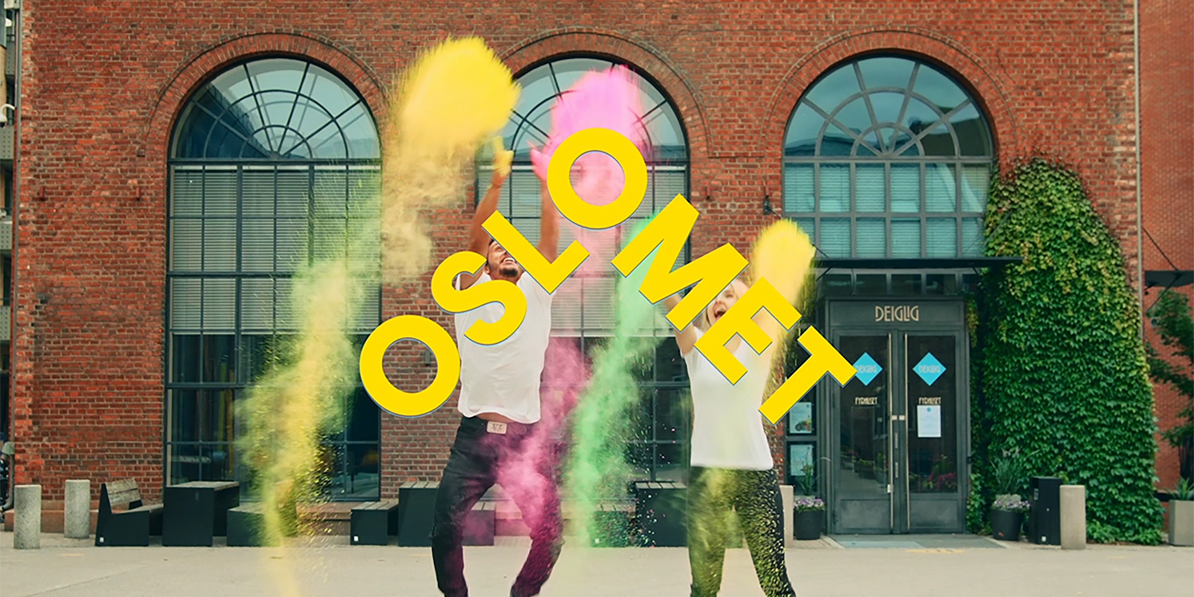 Bilde av to personer som hopper hopp i luften med fargepulver rundt.