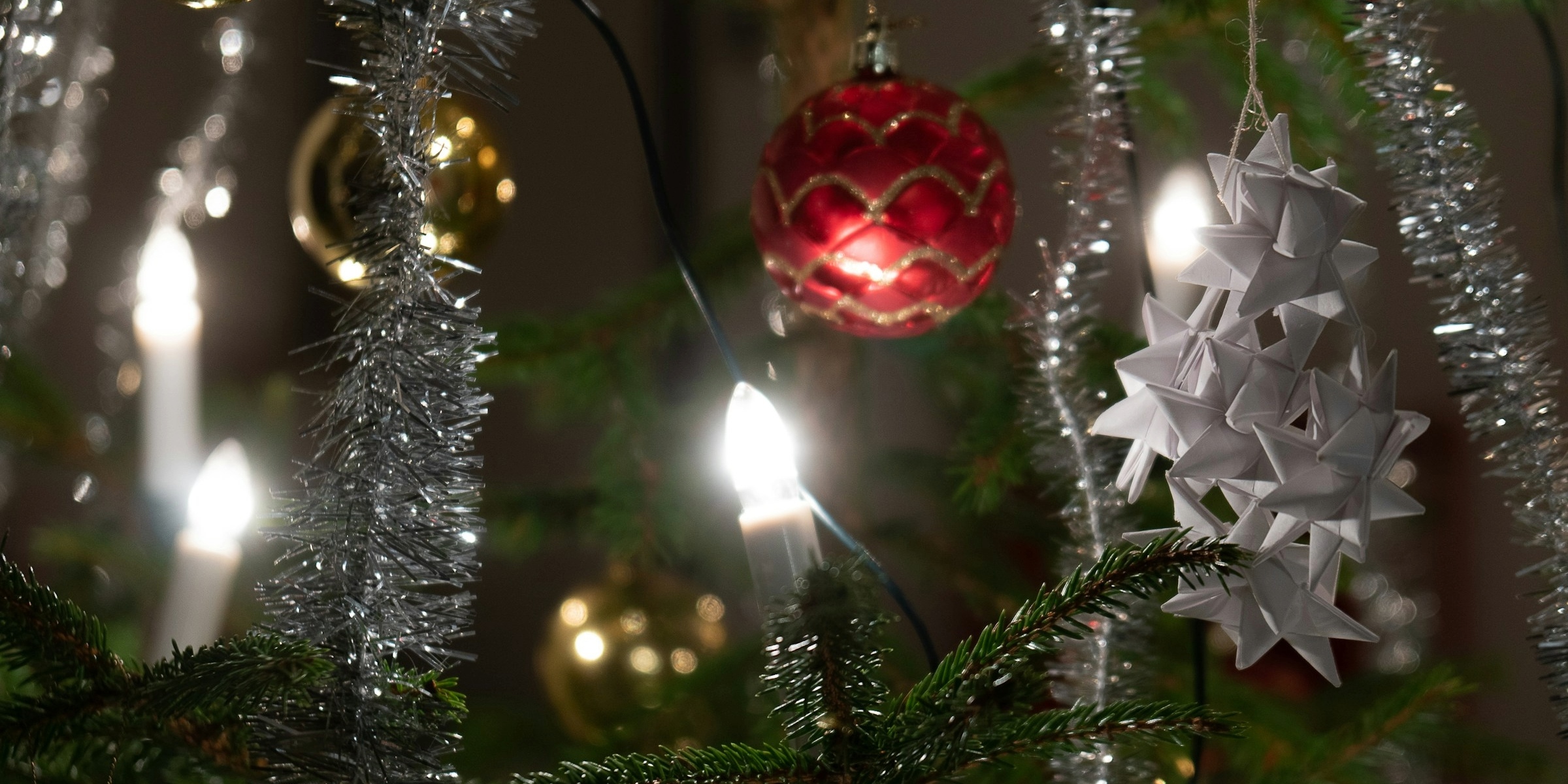 Close-up of a Christmas tree with lights and baubles.