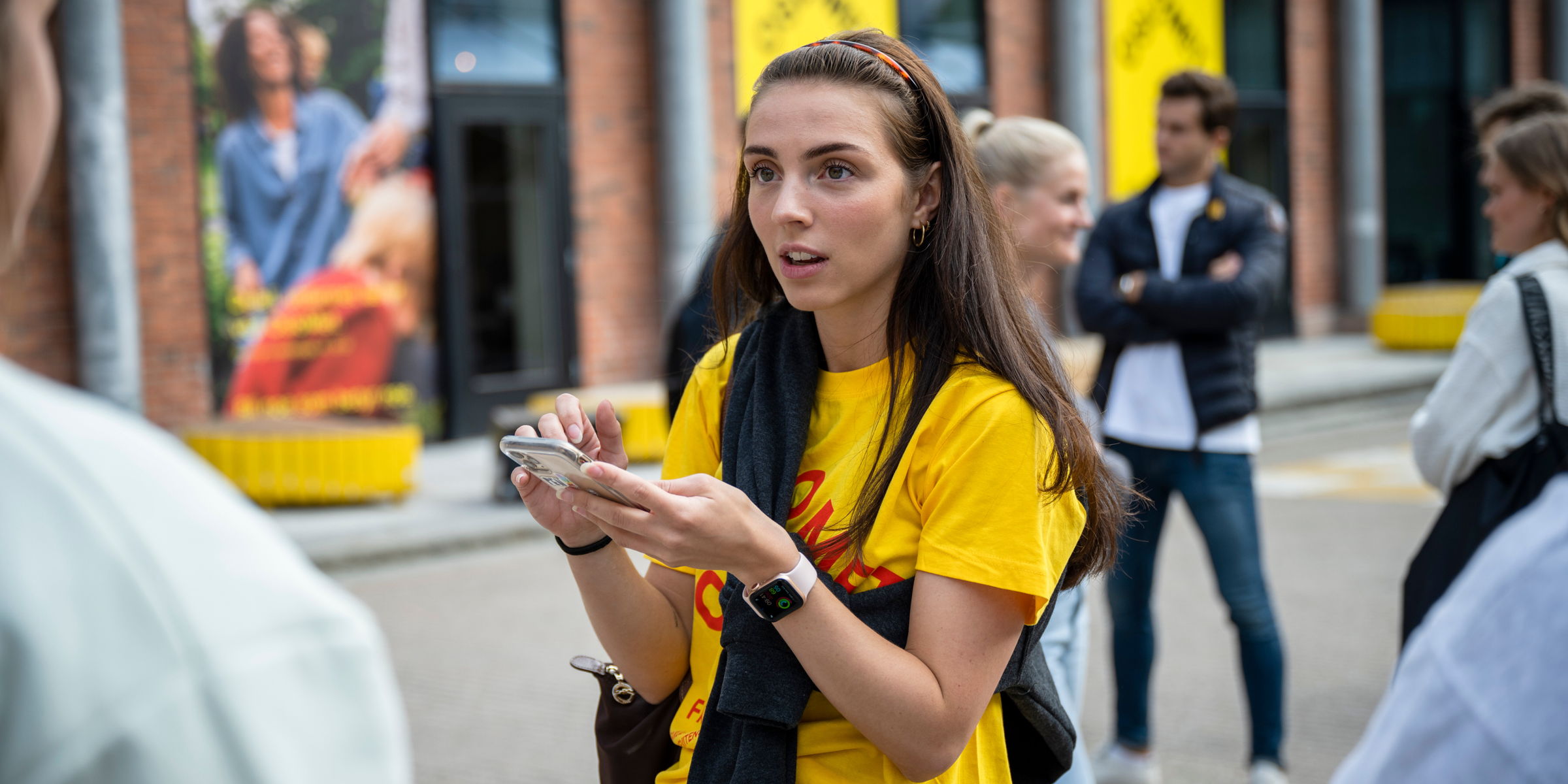 OsloMet student looking up from her mobile phone on the campus in Pilestredet
