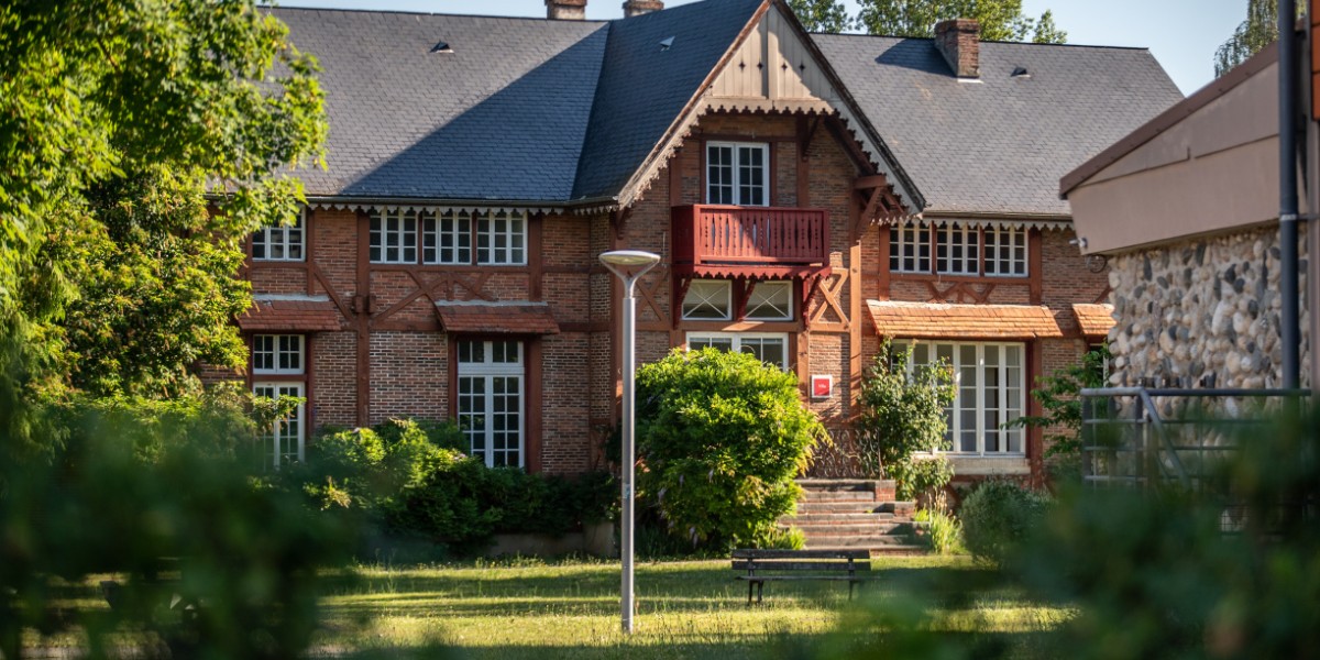 One of the old university buidlings with green trees and lawn in front